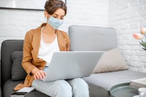 Woman in medical mask working from home